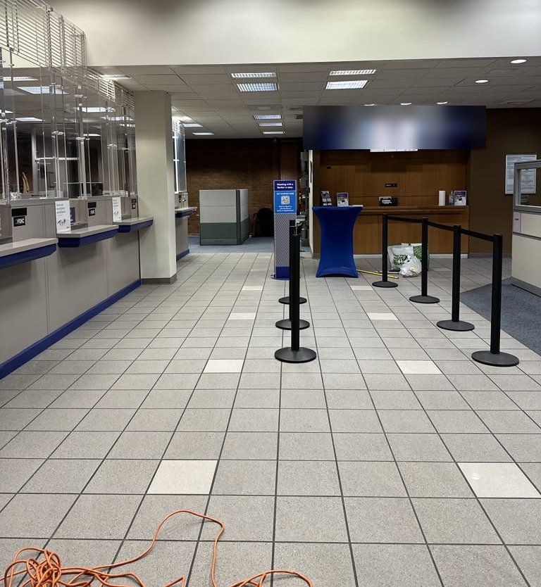 Clean tiled bank lobby with teller windows and queue stanchions