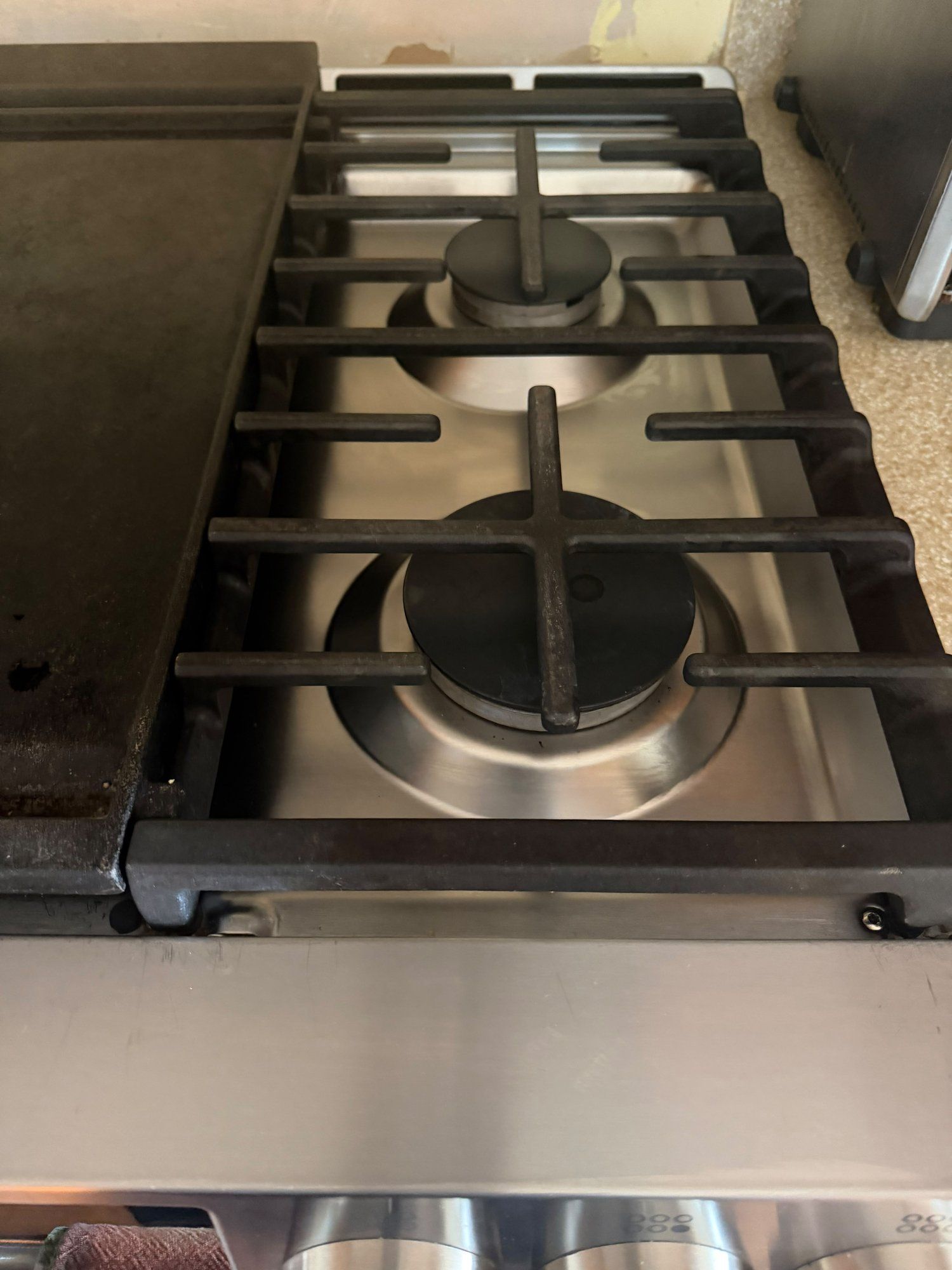 Gas stovetop burners wiped clean after deep cleaning